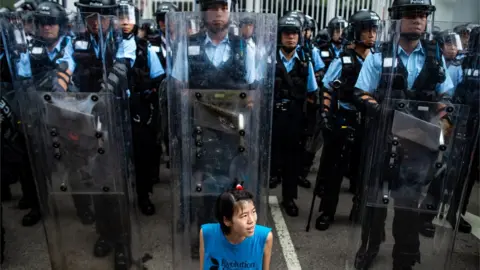 AFP A protester sits in front of riot police outside Legislative Council in Hong Kong