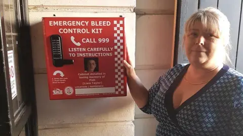 Julie Taylor Julie Taylor with a bleed control kit installed outside a pub