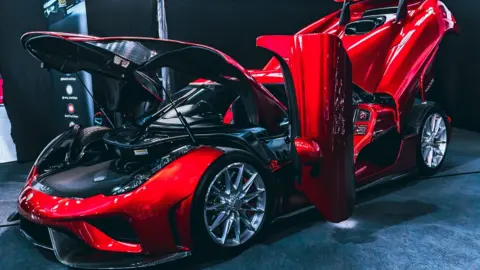 Matthew Wilson Bright red supercar with doors open