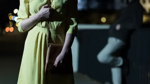 Getty Images Women in dark with man watching her