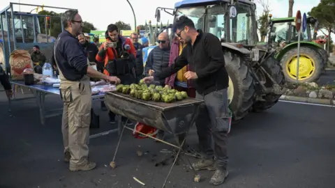 Getty Images Protesting farmers in Barcelona barbecuing artichokes