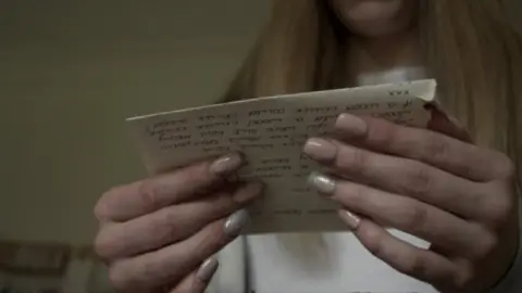 BBC Anonymous woman whose mother was imprisoned reading a letter