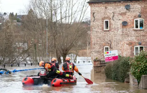 PA Media A Fire and Rescue team in floodwater in Bewdley