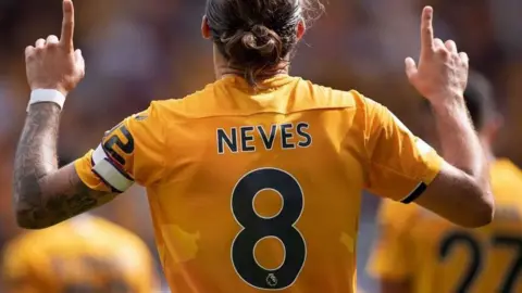 Getty Images A footballer, fingers pointing skywards, with the name Neves and the number eight on the back of his old gold shirt