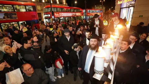 James Manning / PA The group lighting candles one year on