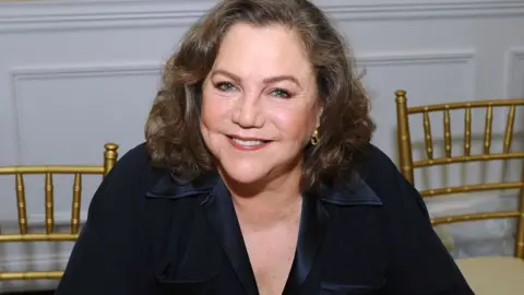 Getty Images Kathleen Turner smiles sitting down in March 2018 event