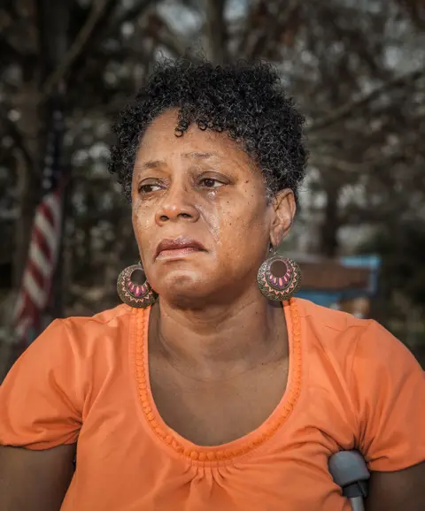 Ian Brown Antoinette Harrell outdoors, with tears running down her face
