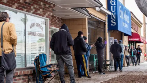 Getty Images Customers queue outside a LA county gun shop