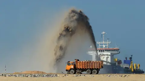 AFP/Getty Pumps dredge sand to reclaim land at the site of a Chinese-funded 1.4 billion USD reclamation project in Colombo on December 5, 2017