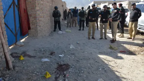 Getty Images Pakistani police officials gather at the site of an attack by gunmen on a polio vaccination team on the outskirts of Quetta on January 18, 2018