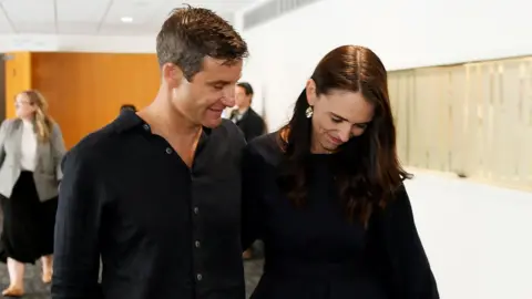 Getty Images New Zealand Prime Minister Jacinda Ardern and partner Clarke Gayford leave after she announces her resignation at the War Memorial Centre on January 19, 2023