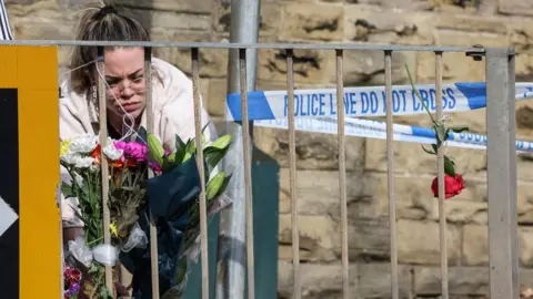 Nigel Roddis/PA Woman laying flowers