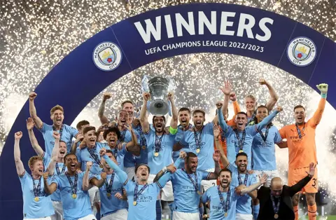 EPA-EFE/REX/Shutterstock Manchester City with the trophy after winning the UEFA Champions League