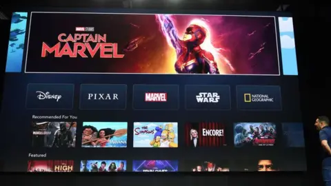 Getty Images A giant screen shows Marvel's Captain Marvel being promoted on the home screen of the Disney+ app