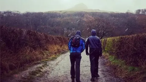 Walkers start to climb Roseberry Topping in the snow