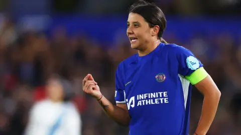 Action Photo/Reuters Mrs. Care wears the Chelsea soccer kit, looks intense.