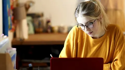 Getty Images Student typing on a laptop in student accommodation