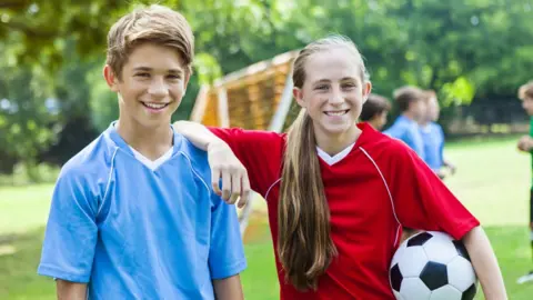 Getty Images boy and girl playing football