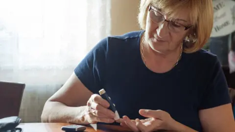 Getty Images Woman testing blood sugars