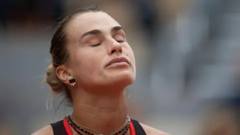 Aryna Sabalenka closes her eyes in disgust during a frustrating French Open quarter-final defeat by Diana Shnaider