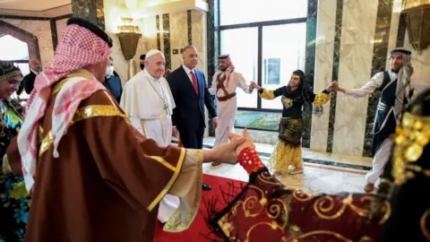 Reuters The Pope was greeted by Iraq's PM and dancers at the airport in Baghdad