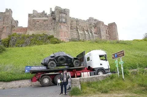 Owen Humphreys/PA Media An armoured vehicle arrives on set at Bamburgh Castle