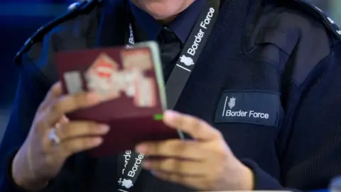 PA Border Force officer checking passport