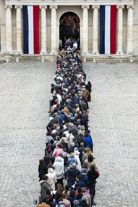 EPA Visitors wait to view the coffin of former French President Jacques Chirac on 29 September 2019.