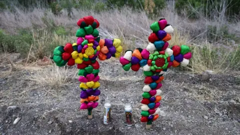 Colourful crosses are left after police impounded the trailer truck in which 50 dead migrants found inside