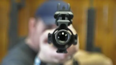 Getty Images A man pointing a gun at the camera