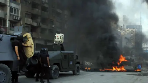 AFP Armoured vehicles approach a flaming barrier in Cairo on 14 August 2013
