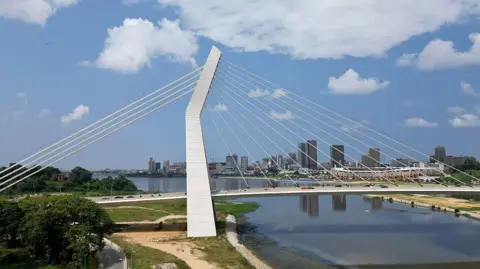 AFP/Getty Images Uma vista aérea da ponte Ouattara em Alassane, no planalto do distrito comercial de Abidjan, em 25 de julho de 2025.