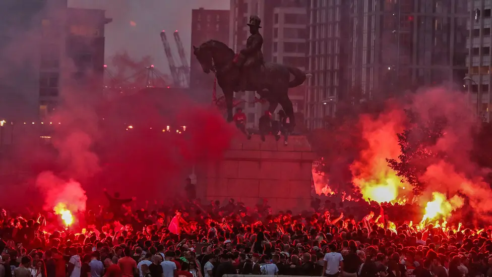 PA Media Flares lit around statue