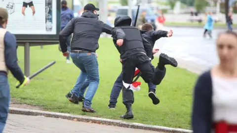 Reuters Unidentified people holding batons chase a man in an attempt to knock him down during an opposition rally to protest against police brutality and to reject the presidential election results in Minsk, Belarus September 6, 2020.