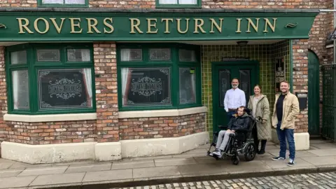 BBC Rob and Lindsey Burrow outside the Rovers Return with Peter Ash and Daniel Brocklebank