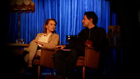 Hannah Higraff Marit Higraff and Neil McCarthy on a darkened stage