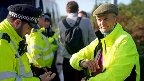 PA Media A police officer detains a protester