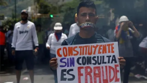 Reuters A demonstrator with his mouth covered holds a sign that reads "Constituent without consultation is fraud" while rallying against Venezuela's President Nicolas Maduro in Caracas, Venezuela June 5, 2017.