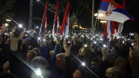 Reuters Protesters in Belgrade wave their mobile phone flashlights. Photo: 24 December 2023