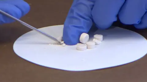 Drug tablets being tested by forensics