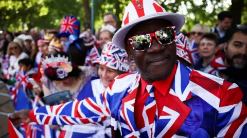 Reuters A man wearing a Union Jack suit looks on as people gather along The Mall for the Queen's Platinum Jubilee celebrations in London