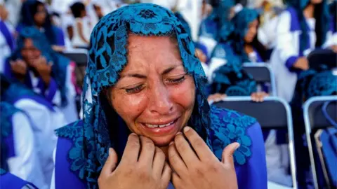 AFP A woman with a blue mantilla cries with emotion during the annual gathering of the Light of the World church