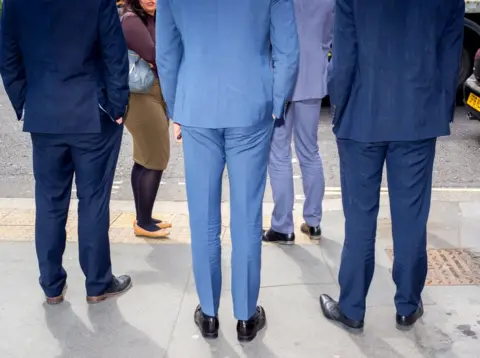 Peter Dench Men in suits wait to cross the road. St Paul's, London.