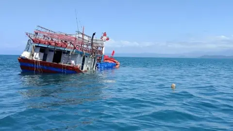 AFP A partially submerged boat that police say was used in a "people smuggling venture"