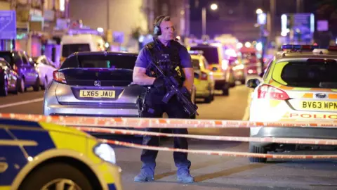 PA An armed police officer at the scene of the Finsbury Park mosque attack