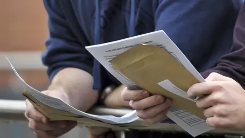 PA Close up students holding results envelopes