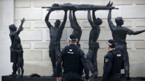 PA Media Police in front of one of Ian Rank-Broadley's sculptures at the National Memorial Arboretum