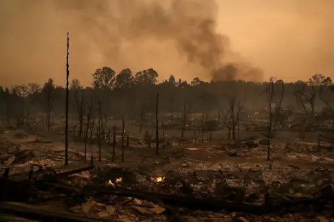 Getty Images Smoke billows from a neighbourhood that was destroyed by a fast-moving wild fire in Santa Rosa, California, 9 October