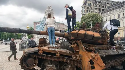 Getty Images People look at destroyed Russian armored vehicles displayed for Ukrainians to see at Mykhailivska Square in downtown Kyiv, Ukraine, May 22, 2022