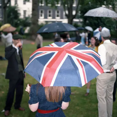 Ed Thompson A woman holding a Union Jack umbrella